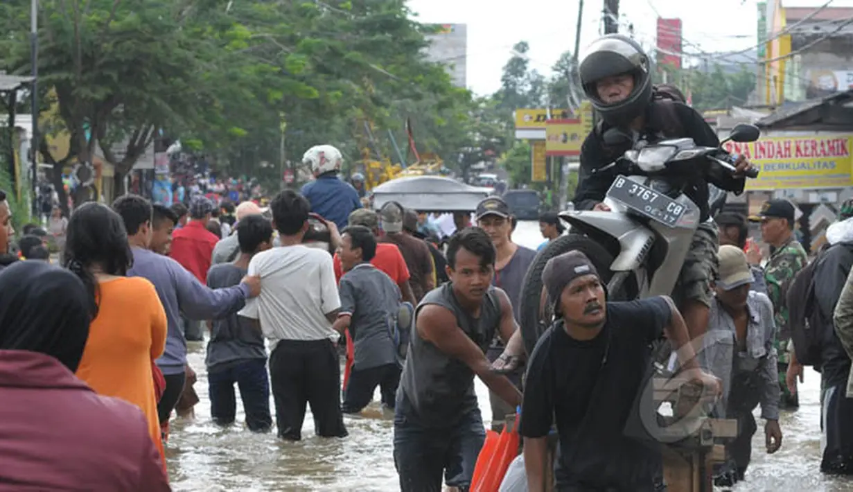 Pengendara sepeda motor memilih menggunakan gerobak untuk melewati banjir di kawasan Jalan KH Hasyim Ashari, Ciledug, Kota Tangerang, Selasa (10/2/2015). (Liputan6.com/Andrian M Tunay)