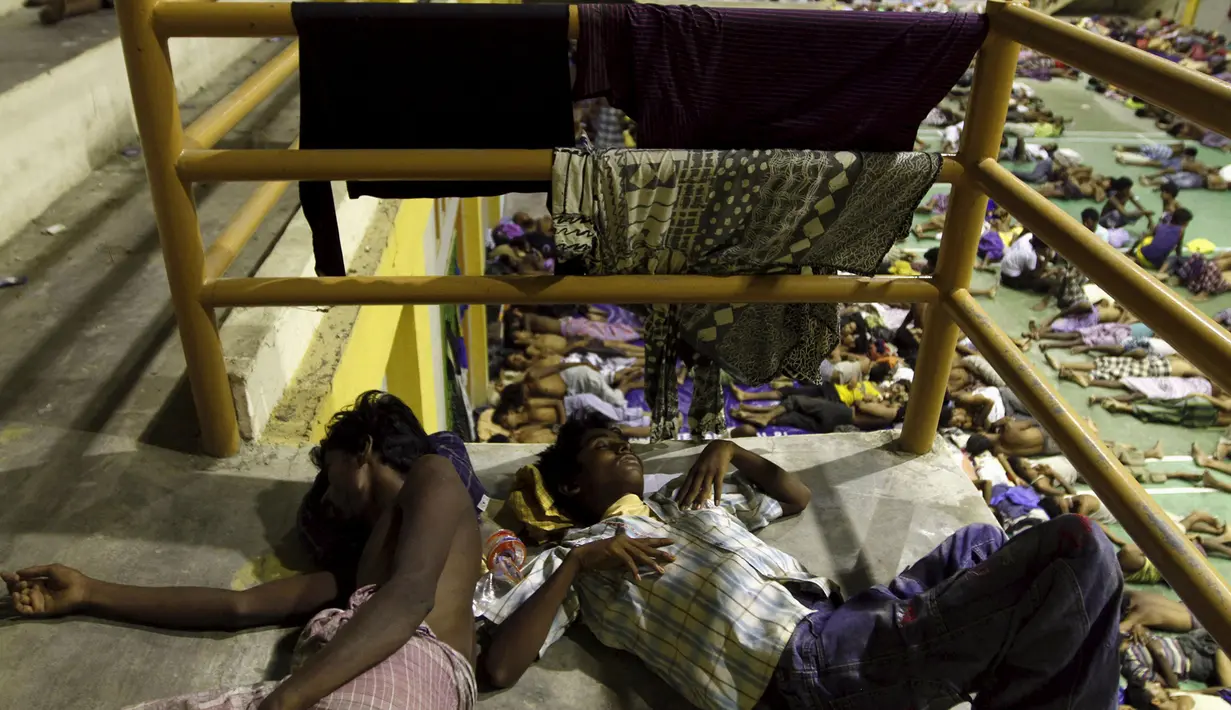 Dua pemuda etnis Rohingya tidur di tempat penampungan di Lhoksukon, Aceh, Senin (11/5/2015). Sekitar 500 migran terdampar di pantai Aceh setelah terapung-apung di laut selama sebulan karena kehabisan bahan bakar. (REUTERS/Roni Bintang)