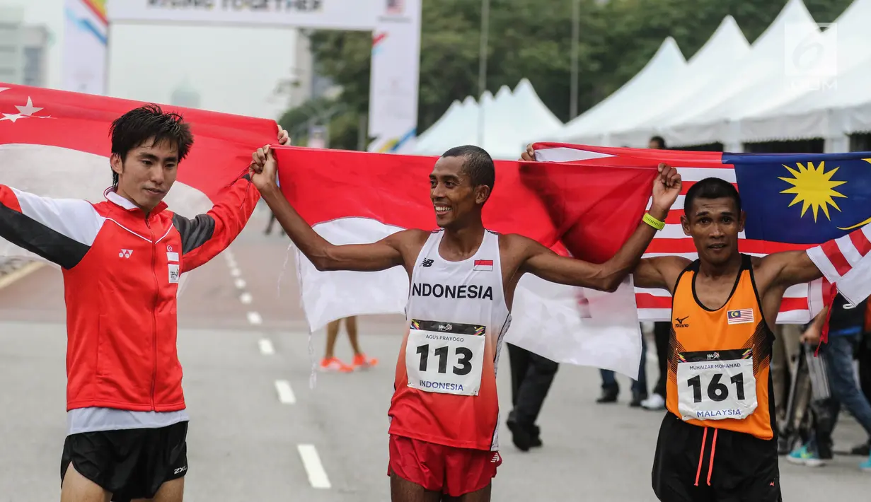 Pelari Indonesia Agus Prayogo (tengah) bersama pelari Singapura  Rui Yong dan pelari Malaysia Muhaizar Mohammad berpose usai melakukan trek maraton SEA Games XXIX di di Putrajaya, Kuala Lumpur, Malaysia, Sabtu (19/8). (Liputan6.com/Faizal Fanani)