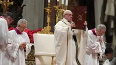 Paus Fransiskus memegang kitab Injil saat memimpin misa Natal di Basilika Santo Petrus, Vatikan, (24/12). Paus menyerukan kepada masyarakat di negara maju agar menjalani kehidupan yang sederhana dan tidak terlalu materialistis. (AFP Photo/Tiziana Fabi)