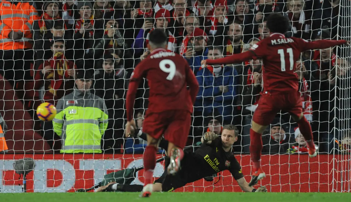 Penyerang Liverpool, Mohamed Salah (kanan) saat memasukan bola lewat titik penalti selama pertandingan melawan Arsenal pada lanjutan Liga Inggris di Anfield Stadium (29/12). Liverpool menang telak atas Arsenal 5-1. (AP Photo/Rui Vieira)