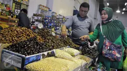 Calon pembeli memilih kurma yang dijajakan di salah satu kios pasar Tanah Abang, Jakarta, Jumat (10/6). Menurut pedagang, penjualan kurma di bulan Ramadan mengalami peningkatan hingga dua kali lipat dibandingkan hari biasanya. (Liputan6.com/Johan Tallo)