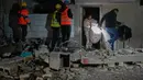 Serangan Israel dan Amerika Serikat tersebut menyebabkan kerusakan signifikan di beberapa wilayah Iran, termasuk gugurnya Pemimpin Tertinggi Iran Ayatollah Ali Khamenei dan pejabat militer lainnya. Tampak dalam foto, warga membawa barang-barang pribadi mereka saat meninggalkan gedung yang rusak akibat serangan rudal Iran di Tel Aviv, Israel, Sabtu 28 Maret 2026 pagi waktu setempat. (AP Photo/Maya Levin)