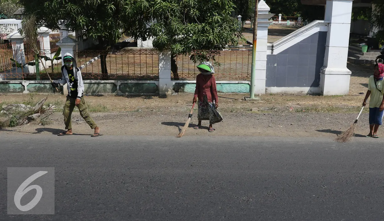 Warga di kawasan Subang menjadi Penyapu jalan (Tawur), Jabar, Senin (11/7). Para pemudik biasa melempar uang receh yang akan disapu oleh warga sekitar yang menjadi Tawur. (Liputan6.com/Herman Zakharia)