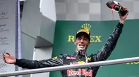 Pembalap Red Bull Daniel Ricciardo menunjukkan sepatu miliknya usai merayakan keberhasilan naik podium pada Grand Prix Formula 1 Jerman, Minggu (31/7). Ricciardo yang menjadi juara kedua meminum sampanye menggunakan sepatunya. (Patrik STOLLARZ / AFP)