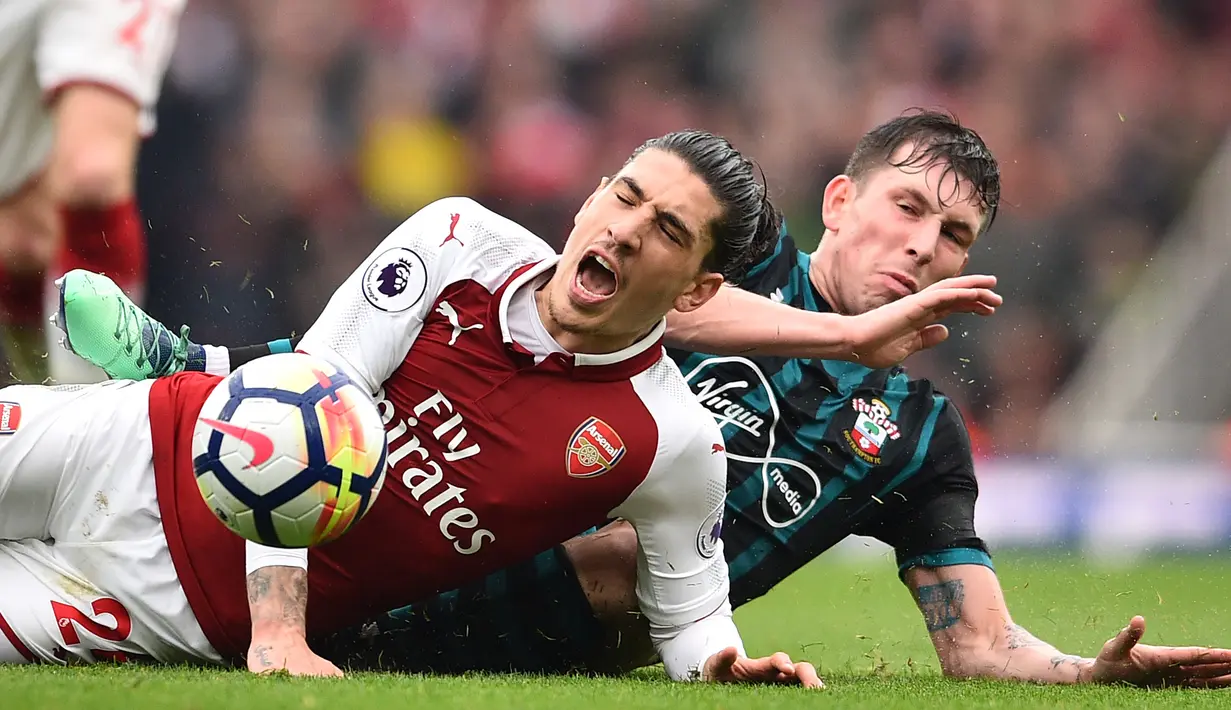 Gelandang Southampton Pierre-Emile Hojbjerg berebut bola dengan pemain belakang Arsenal Hector Bellerin dalam lanjutan Premier League 2017/2018 di Stadion Emirates, Minggu (8/4). Arsenal menang tipis dengan skor 3-2 atas Southampton. (Glyn KIRK / AFP)