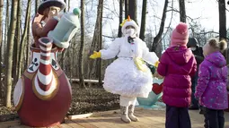 Seorang pemandu wisata yang mengenakan kostum karakter dongeng Rusia, Putri Salju, mengobrol dengan anak-anak dalam pembukaan "Jalur Dongeng" di "Kediaman Kakek Frost" di Moskow, Rusia (18/11/2020). (Xinhua/Alexander Zemlianichenko Jr)