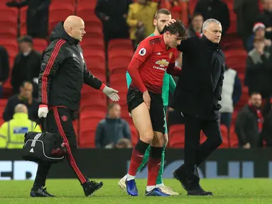 Bek Manchester United, Victor Lindelof dipapah usai menderita cedera kontra Crystal Palace pada laga lanjutan Premier League yang berlangsung di stadion Old Trafford, Manchester, Minggu (25/11). MU bermain imbang 0-0. (AFP/Lindsay Parnaby)