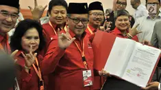 Sekjen PDIP Hasto Kristiyanto (tengah) menunjukkan daftar bakal caleg ke KPU di Jakarta, Selasa (17/7). Hasto tampak beberapa kali mengacungkan salam metal. (Merdeka.com/Iqbal Nugroho)