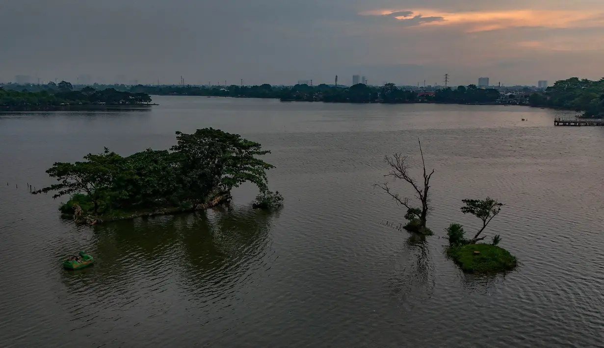 Permukaan air yang tenang menghadirkan panorama dengan daya tarik tersendiri. Tampak foto udara memperlihatkan area Situ Cipondoh di Kota Tangerang, Banten, yang tetap berfungsi sebagai kawasan konservasi air sekaligus destinasi rekreasi warga, Rabu (14/4/2026). (merdeka.com/Arie Basuki)