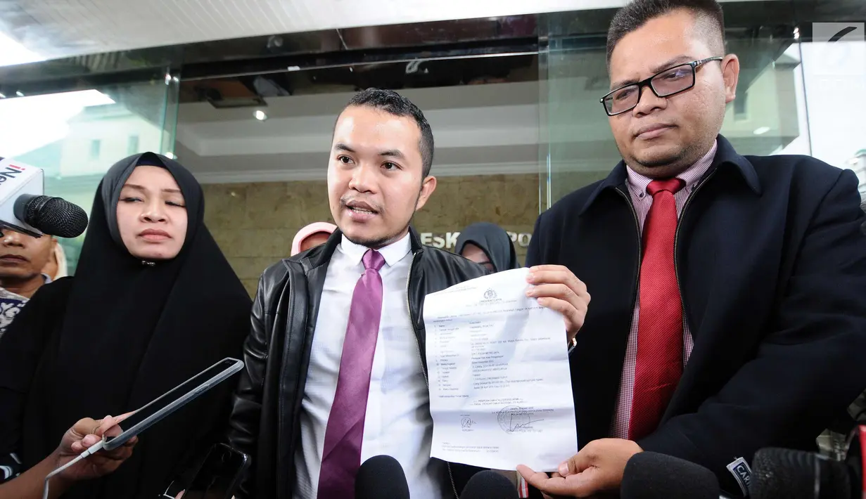 Tim kuasa hukum calon jamaah umrah menunjukkan berkas laporan penipuan yang dikeluarkan Polda Metro Jaya usai konsultasi pelaporan dugaan penipuan salah satu agen perjalanan di Bareskrim Mabes Polri, Jakarta, Senin (5/2). (Liputan6.com/Helmi Fithriansyah)