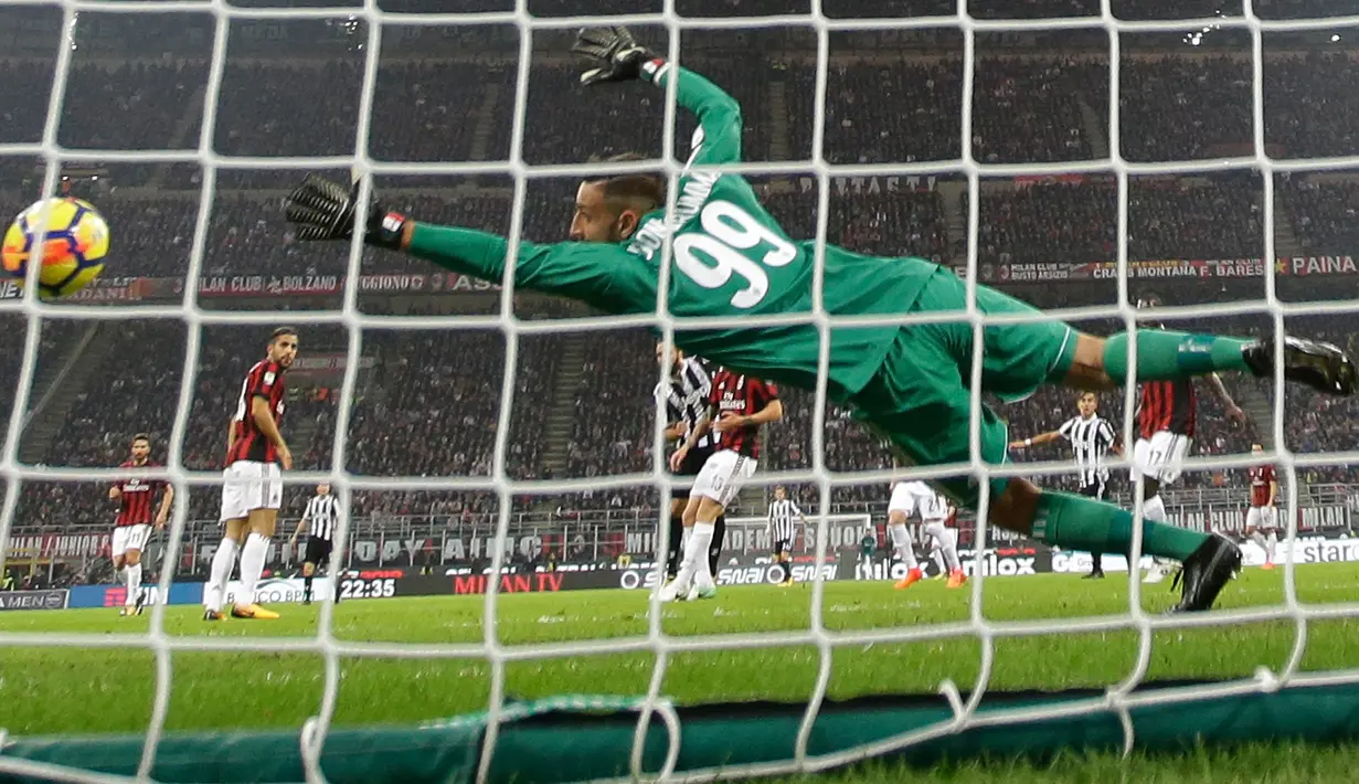 Kiper AC Milan, Gianluigi Donnarumma gagal menangkap bola yang ditendang pemain Juventus, Gonzalo Higuain pada lanjutan Serie A Italia di Stadion San Siro, Milan, Sabtu (28/10). Lewat Higuain, Juve memetik kemenangan dua gol tanpa balas. (AP/Luca Bruno)