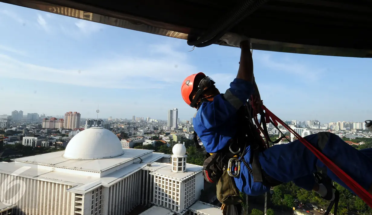 Salah satu relawan pecinta alam membersihkan atap menara Masjid Istiqlal, Jakarta, Jumat (17/2). Menyambut Milad Masjid Istiqlal ke-39, relawan pecinta alam bantu membersihkan Masjid Istiqlal. (Liputan6.com/Helmi Fithriansyah)
