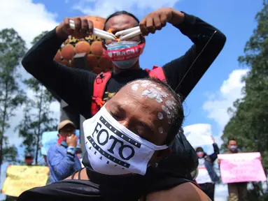 Seorang jurnalis melakukan aksi teatrikal saat aksi solidaritas di kawasan Tugu Adipura, Kota Tangerang, Rabu (31/3/2021). Mereka menuntut pihak berwenang mengusut tuntas oknum pelaku kekerasan terhadap wartawan Tempo, Nurhadi dan kasus kekerasan jurnalis lainnya. (Liputan6.com/Angga Yuniar)