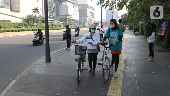 Warga berolahraga menggunakan sepeda di Bunderan HI Jakarta, Minggu (7/6/2020). Aturan itu tertuang dalam pasal 16 ayat 1 mengenai kegiatan sosial budaya.  (Liputan6.com/Herman Zakharia)
