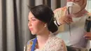 Melengkapi tampilannya dengan anting-anting bunga warna emas. Serta tusuk konde emas di atas rambut sanggulnya. Wajahnya dipoles blush on pink senada dengan lipstiknya.  [@arumibachsin_94]