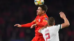 Gelandang Timnas Wales, Aaron Ramsey berebut bola dengan bek Timnas Hungaria Adam Lang pada laga Grup E Kualifikasi Piala Eropa 2020 di Cardiff City Stadium, Selasa (19/11/2019). Wales memastikan satu tempat di putaran final Piala Eropa 2020 setelah mengalahkan Hungaria 2-0. (Paul ELLIS/AFP)