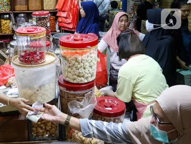 Warga membeli kue kering di salah satu pusat penjualan kue di pasar Jatinegara, Jakarta, Kamis (28/3/2024). (Liputan6.com/Herman Zakharia)