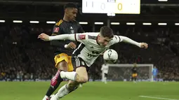 Bek Leeds United Junior Firpo berebut bola dengan gelandang Fulham Harry Wilson pada pertandingan putaran kelima Piala FA 2022/2023 di Craven Cottage di London, Rabu (28/2/2023) dini hari WIB. Fulham menyingkirkan Leeds United dengan kemenangan 2-0. (AP Photo/Ian Walton)