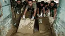 Rumah Sakit Daerah Aceh Tamiang mulai kembali beroperasi secara bertahap setelah sempat lumpuh total akibat banjir bandang pada akhir November 2025 lalu. Tampak dalam foto, personel Tentara Nasional Indonesia (TNI) dari YONIF TP 853/BRB, Aceh Timur, membersihkan lumpur di Rumah Sakit Daerah di Aceh Tamiang, pada Selasa 16 Desember 2025, setelah banjir bandang sekitar tiga minggu lalu. (Yasuyoshi Chiba/AFP)