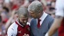 Pelatih Arsenal, Arsene Wenger, berbincang dengan Jack Wilshere saat perpisahan di Stadion Emirates (6/5/2018). Selama 22 tahun membesut Arsenal, Wenger telah mempersembahkan 17 gelar dan 704 Kemenangan. (AFP/Ian Kington)