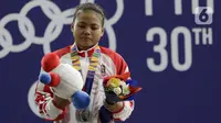 Lifter putri Indonesia, Lisa Setiawati saat naik podium usai mendapatkan medali perak SEA Games 2019 cabang angkat besi nomor 45 kg di Stadion Rizal Memorial, Manila, Minggu (1/12/2019). Dirinya meraih perak dengan total angkatan 169 kg. (Bola.com/M Iqbal Ichsan)