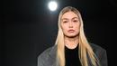 Gigi Hadid mempersembahkan kreasi Prada selama Koleksi Wanita Musim Gugur-Musim Dingin 2023-2024 sebagai bagian dari Fashion Week di Milan pada 23 Februari 2023. Gigi melengkapi penampilannya dengan make-up minimalis dan memakai bulu mata palsu merah muda untuk membuat mata birunya menonjol. (AFP/Marco Bertorello)