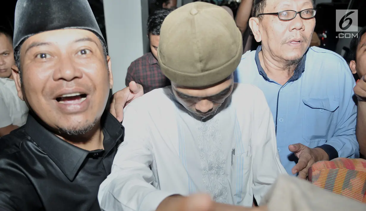 Ustaz Abdul Somad (UAS) berusaha menghindari kerumunan awak media setibanya di Kantor Majelis Ulama Indonesia (MUI), Jakarta, Rabu (21/8/2019). UAS memenuhi undangan MUI untuk menyampaikan klarifikasi mengenai video ceramahnya yang viral dan memicu polemik. (merdeka.com/Iqbal S Nugroho)