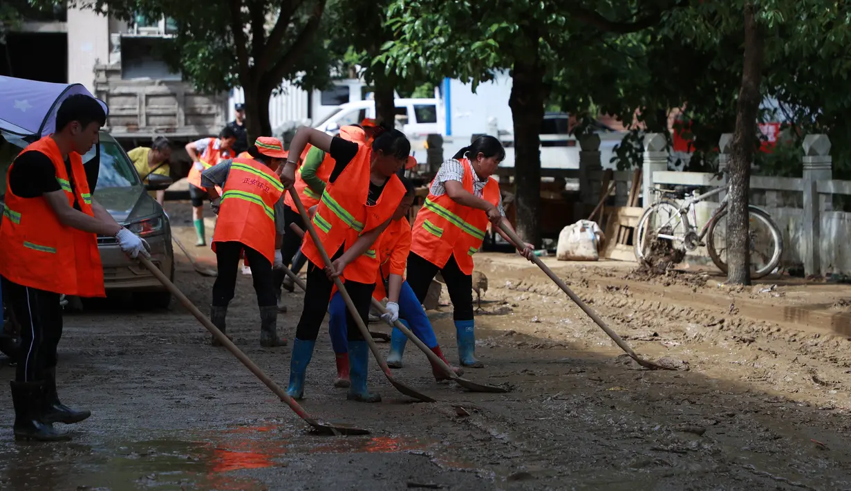 Regu penyelamat membersihkan endapan lumpur di jalanan Kota Bifeng, Provinsi Guizhou, China, Sabtu (13/6/2020). Banjir yang dipicu oleh hujan telah berdampak pada kehidupan 700.000 orang di Provinsi Guizhou. (Xinhua/Liu Xu)