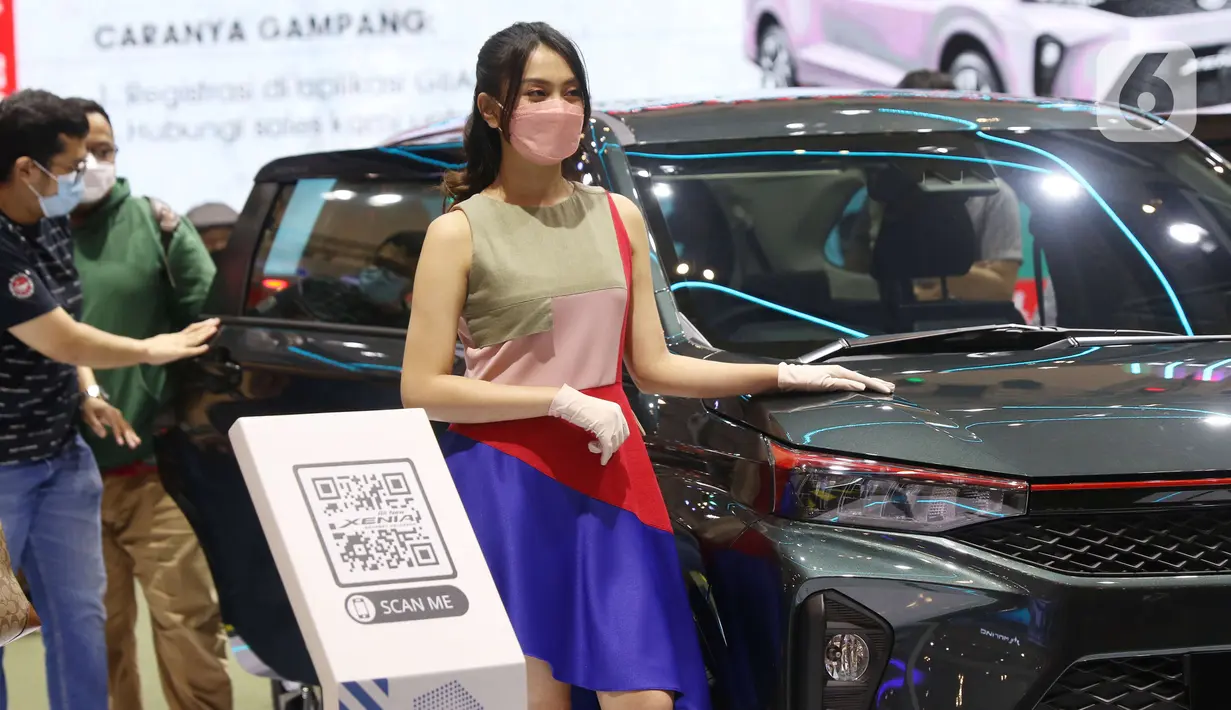 Seorang Sales Promotion Girl (SPG) berdiri di samping kendaraan pada Gaikindo Indonesia International Auto Show (GIIAS) 2021 di ICE BSD, Tangerang, Senin (15/11/2021). Kehadiran model menghiasi pameran otomotif GIIAS 2021 yang berlangsung hingga 21 November mendatang. (Liputan6.com/Angga Yuniar)