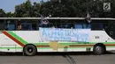 Sebuah spanduk terpampang di bus yang mengangkut buruh saat melakukan aksi May Day 2018 di Jalan Medan Merdeka Timur, Jakarta, Selasa (1/5). (Liputan6.com/Arya Manggala)