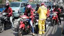 Petugas Sudin Bina Marga Jakarta Barat membagikan masker dan pasta gigi kepada pengendara motor di Jalan KS Tubun, Petamburan, Kamis (23/5/2019). Sisa gas air mata untuk membubarkan massa dalam kericuhan aksi 22 Mei masih terasa dan mengganggu aktvitas pengguna jalan (Liputan6.com/Immanuel Antonius)