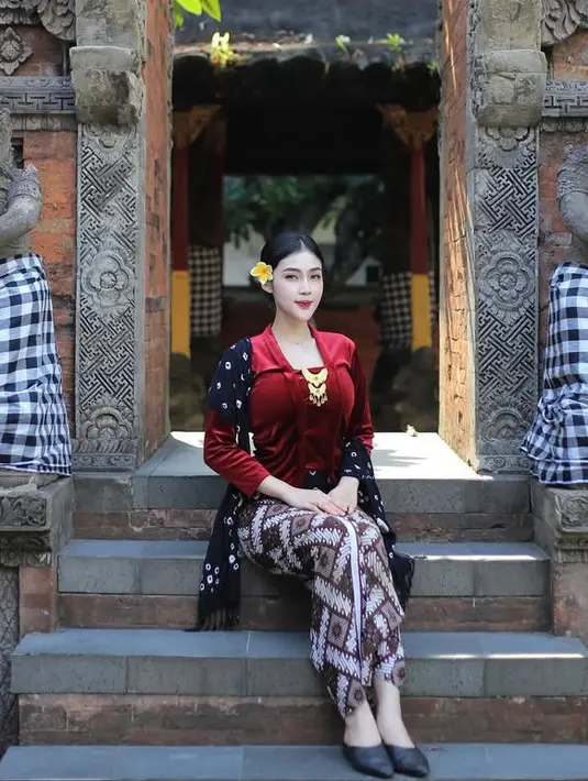 Saat liburan ke Yogyakarta, Eby pun memilih mengenakan kebaya velvet merah dihiasi bros keemasan. Ia memadukannya dengan selendang jumputan dan bawahan kain batiknya. [@kinen_bhy]