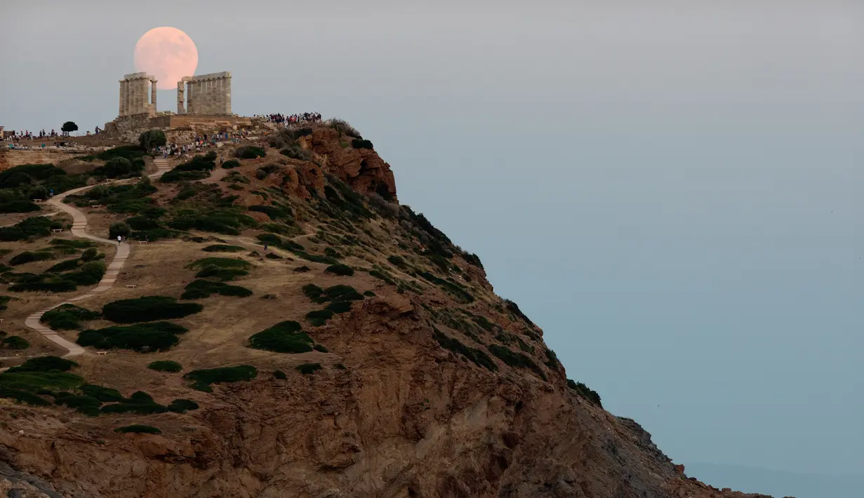 Pemandangan bulan purnama hampir penuh yang menampakkan diri di langit Kuil Poseidon kuno di Cape Sounion, sekitar 70 kilometer sebelah tenggara Athena, Yunani (2/8/2020). (Xinhua/Marios Lolos)