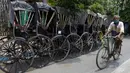 Seorang pria mengayuh sepeda melewati becak yang diparkir di Kolkata, India, Rabu (9/6/2021). India melonggarkan sebagian pembatasan untuk mengekang penyebaran virus corona COVID-19. (AP Photo/Bikas Das)