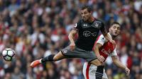 Bek Southampton, Cedric Soares, membuang bola dari jangkauan striker Arsenal, Lucas Perez. Pada laga ini wasit mengeluarkan tujuh kartu kuning, dua untuk Arsenal, sisanya untuk pemain Southampton. (AFP/Ikimages)
