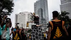 Atraksi seorang pria saat melakukan fahombo atau lompat batu dalam sebuah acara pagelaran seni dan kebudayaan Nias di Jalan Imam Bonjol, Jakarta, Minggu (12/2). Pagelaran ini diselenggarakan oleh Pemuda Peduli Nias. (Liputan6.com/Faizal Fanani)