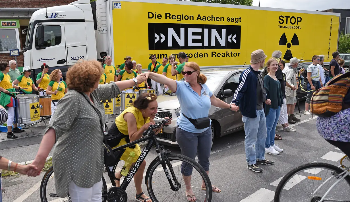 Demonstran membentuk rantai manusia untuk menuntut penutupan reaktor nuklir di Aachen, Jerman barat, 25 Juni 2017. Ada dua reaktor nuklir yang diminta agar ditutup, yakni reaktor nuklir Tihange dan reaktor nuklir Doel di Belgia. (Henning Kaiser/dpa/AFP)