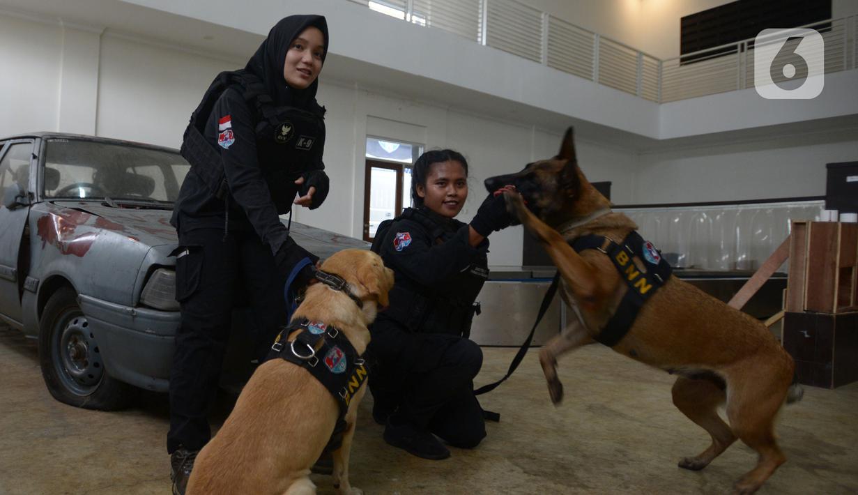 Pelatih wanita Putri Istyan dan Widiya Hutahean berpose dengan anjing K9 di Markas Komando K9 BNN, Selasa (8/3/2022). Pelatih K9 wanita menjalankan tugas yang biasa dilakukan kaum pria dalam memerangi peredaran narkoba baik jaringan internasional maupun nasional. (merdeka.com/Imam Buhori)