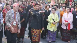 Presiden Joko Widodo dan Ibu Negara Iriana mengenakan pakaian adat Bali tiba menghadiri Karnaval Budaya Bali, Jumat (12/10). Karnaval tersebut untuk mengenalkan kepada delegasi  IMF - WB Group 2018 tentang budaya Bali. (Liputan6.com/Angga Yuniar)