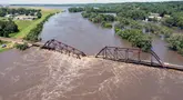 Air banjir melintasi jembatan kereta api yang runtuh di atas Sungai Big Sioux di dekat North Sioux City, South Dakota, pada hari Senin, 24 Juni 2024. (AP Photo/Josh Jurgens)