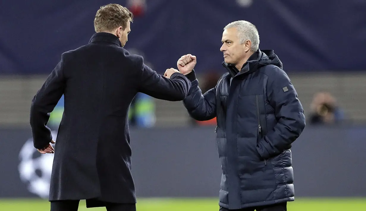 Pelatih Tottenham Hotspur, Jose Mourinho dan pelatih RB Leipzig Julian Nagelsmann menyentuh lengan mereka alih-alih berjabat tangan karena virus corona usai pertandingan leg kedua babak 16 besar Liga Champions di Red Bull Arena, Jerman (10/3/2020). (AP Photo/Michael Sohn)