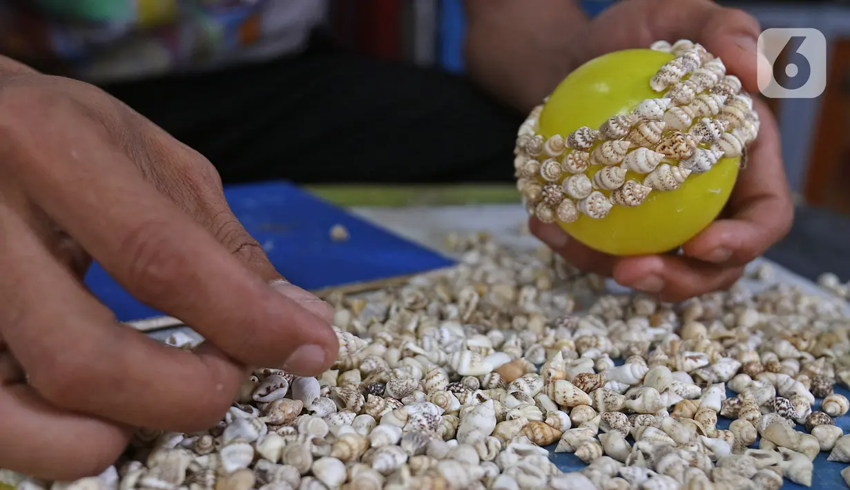 Perajin menyelesaikan pembuatan kerajinan dari kerang di Kawasan Ancol Jakarta, Kamis (14/11/2019). Limbah cangkang kerang itu dimanfaatkan Sugiro (39) untuk dibuat menjadi berbagai kerajinan dengan harga jual mulai Rp 20ribu hingga jutaan tergantung tingkat kesulitan. (Liputan6.com/Herman Zakharia)