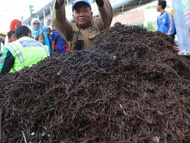 Relawan dari Komunitas Sapu Bersih (Saber) berhasil menemukan 1,5 ton ranjau paku dari sejumlah ruas jalan Ibu Kota di Bundaran HI, Jakarta, Minggu (7/8). (Liputan6.com/Angga Yuniar)