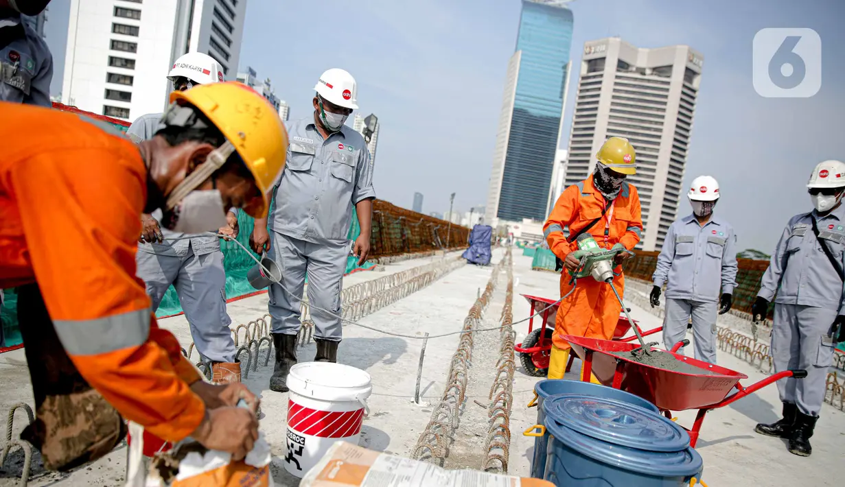 Pekerja mengecek perlintasan LRT di jembatan bentang panjang Dukuh Atas, Jakarta, Rabu (11/11/2020). Jembatan bentang panjang hari ini melakukan pengecoran terakhir panjangnya 128 meter. pekerjaan ini menandai selesainya pengerjaan lintasan atas LRT Jabodebek tahap I. (Liputan6.com/Faizal Fanani)