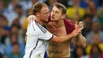 Seorang penggemar nakal yang biasa disebut streaker, masuk ke lapangan dan ingin mencium Benedikt Hoewedes, Senin (14/7) (Julian Finney/Getty Images)