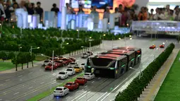 Model Bus yang mengangkangi jalan melawati mobil di sebuah pameran di Beijing, Cina, (19/5). Menurut perancangnya, Song Youzhiu, per tahun bus ini akan menghemat 800 ton bahan bakar dan mencegah hampir 2.500 ton emisi gas buang. REUTERS/Hu Qingming)