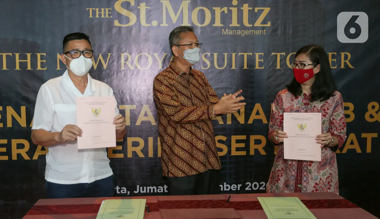 Associate Director PT.Mandiri Cipta Gemilang Darwin A Roni (tengah) berbincang dengan pemilik unit Efemia Surjawati dan Edy Djunaidi pada serah terima sertifikat bangunan apartemen The New Royal Suite Tower, kawasan St. Moritz, Puri Kembangan, Jakarta, Jumat (18/12/2020). (Liputan6.com/Pool)