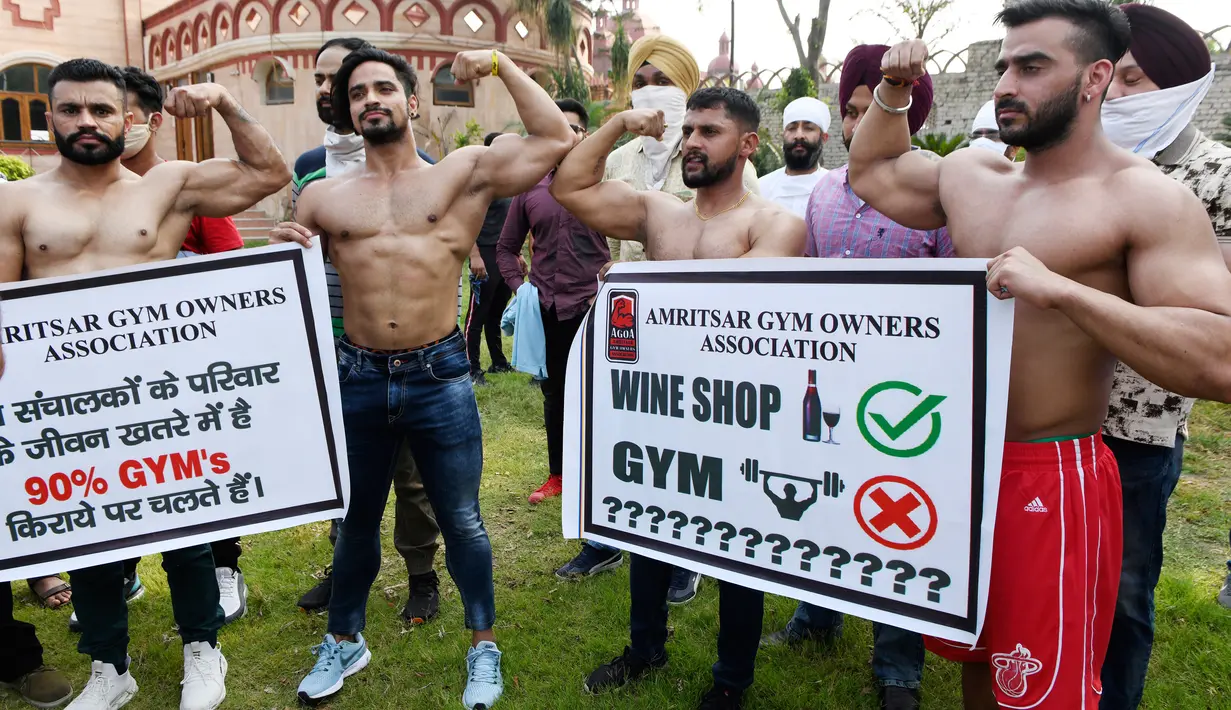 Pemilik dan pelatih gym memegang spanduk saat protes menuntut pemerintah membuka kembali pusat kebugaran di Amritsar, India, Minggu (7/6/2020). Mereka meminta aktivitas tempat olahraga gym juga diizinkan buka setelah pelonggaran lockdown, bukan hanya kegiatan perekonomian.  (NARINDER NANU/AFP)