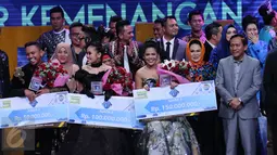 Weni (tengah) memamerkan hadiah yang didapat usai dinobatkan menjadi juara D'Academy Asia 2 di Studio 5 Indosiar, Jakarta, Kamis (29/12). Weni berhasil unggul atas dua finalis lainnya, Rani dan Irsya ditempat ketiga. (Liputan6.com/Helmi Fithriansyah)